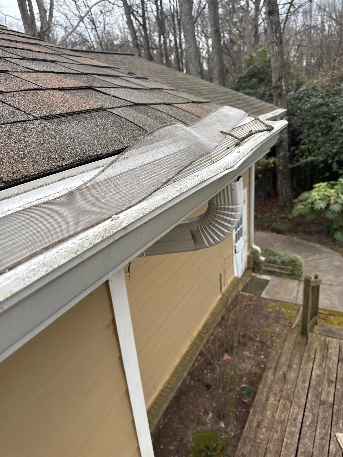 Exterior home view showing deteriorated or damaged 6-inch gutters and downspouts.
