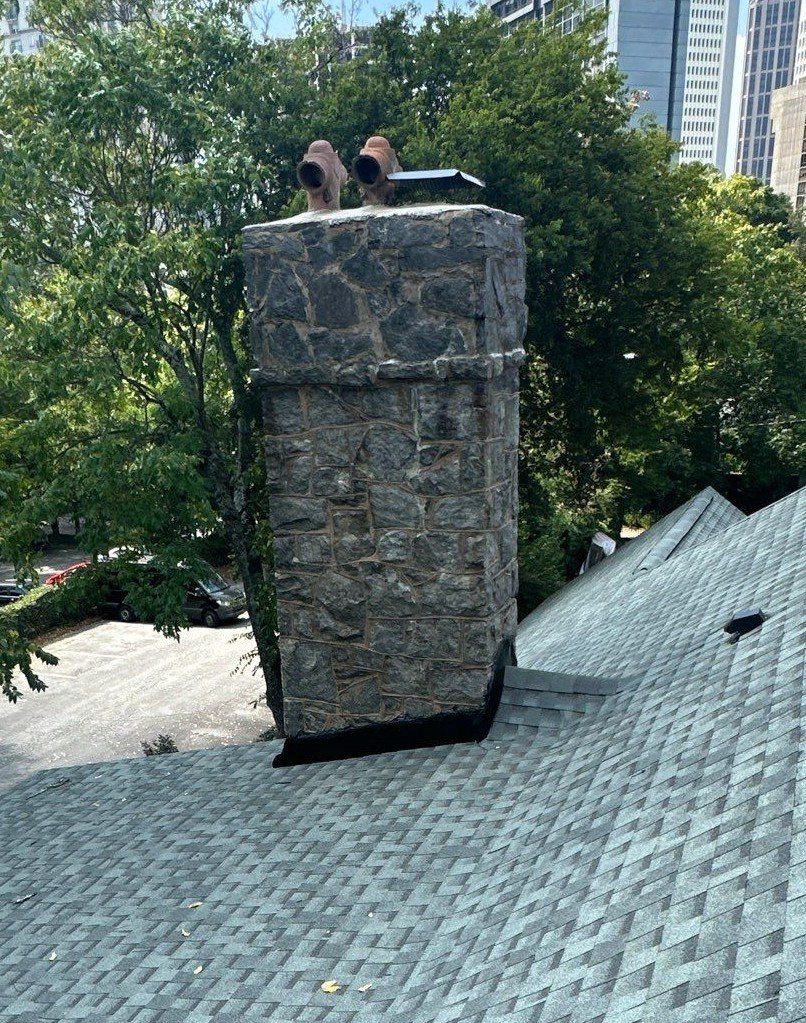 Newly installed black log-and-seal chimney flashing on an Atlanta multi-family building.