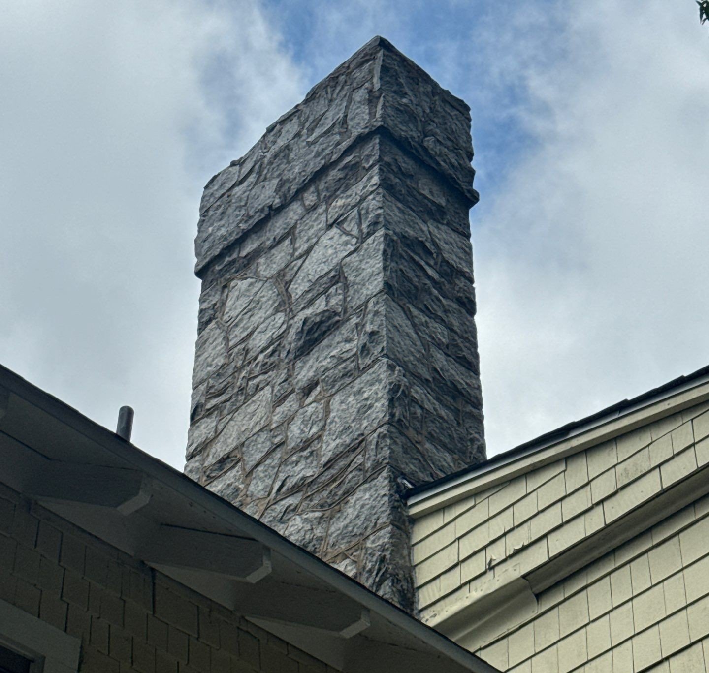 Rusted and peeling chimney flashing on an Atlanta apartment roof causing potential water leaks.
