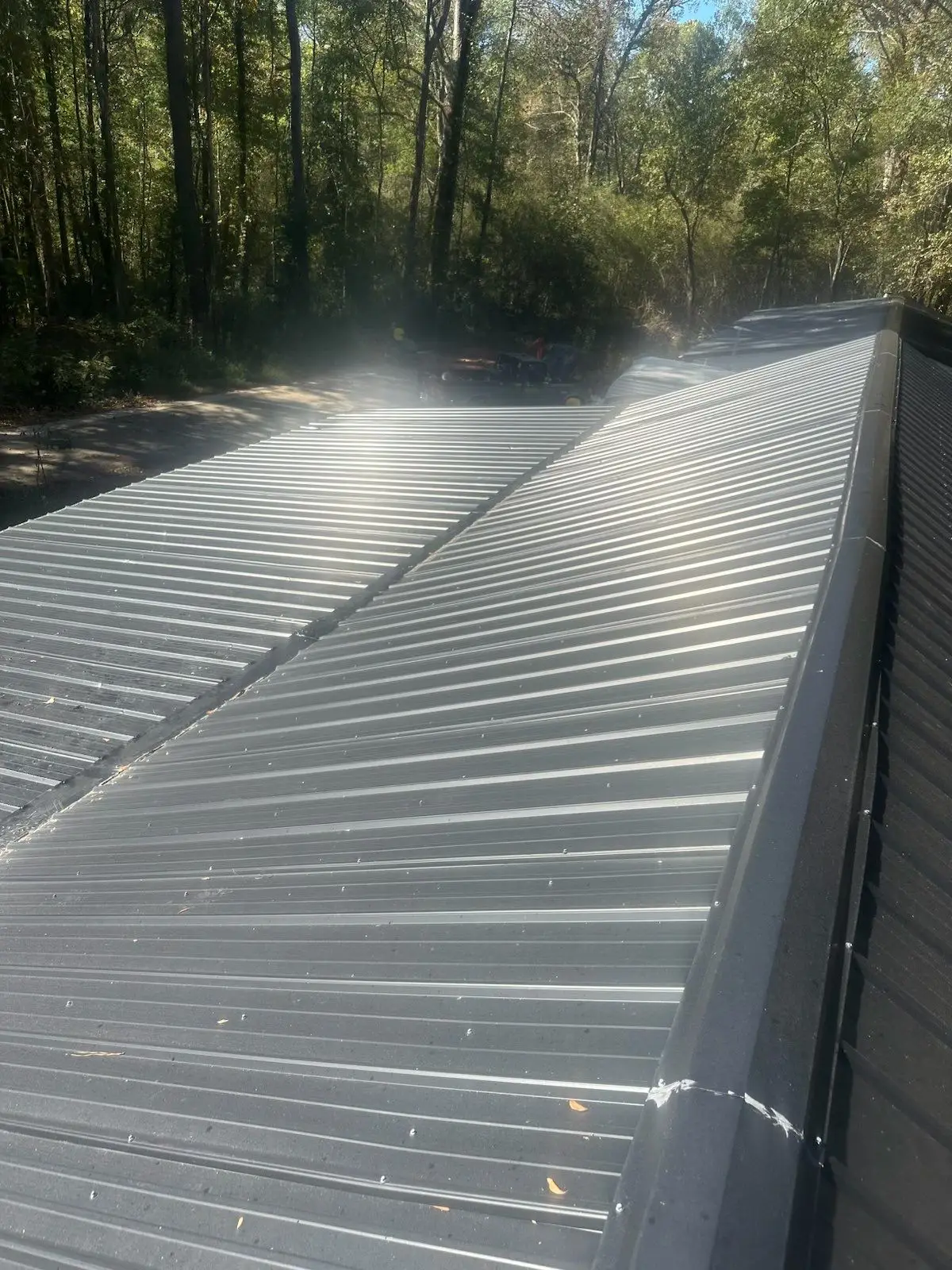 New, dark-colored Standing Seam Metal Roofing system installed on the porch structure, providing modern, durable coverage.