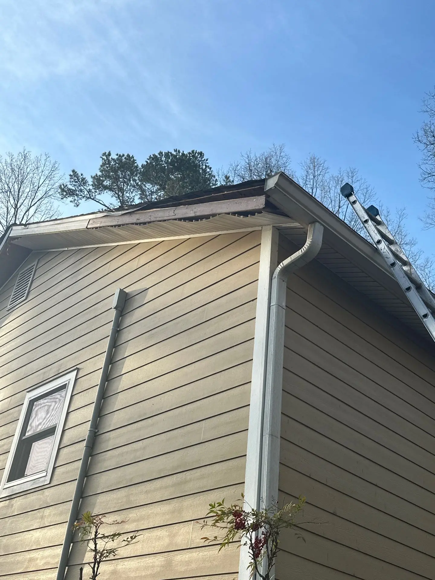 Right roof slope of a home in Marietta, GA showing damaged wood decking and siding prior to repair.