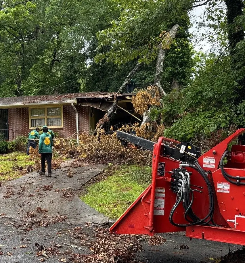 Residential home in East Point, GA, showing severe roof damage, emergency tarping, and visible structural impact near the carport.